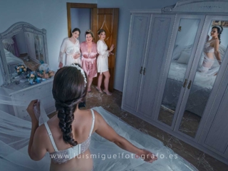 Damas de honor ayudando a vestir a la novia