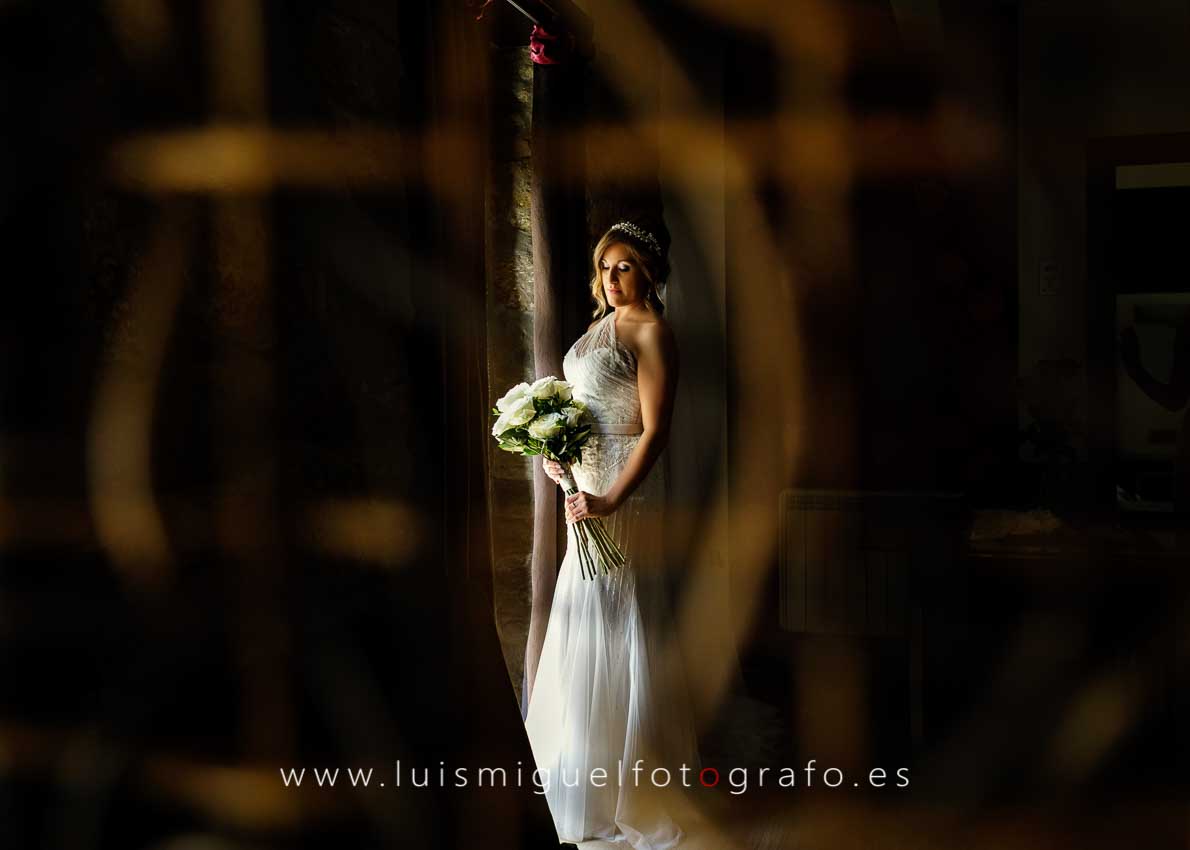 La novia mirando su ramo en su habitación saliendo para la ceremonia
