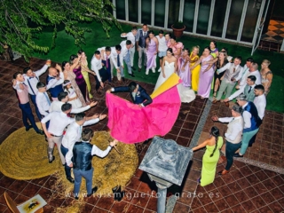 Los amigos arengan al novio en el salon de bodas mientras da unos pases de toreo de salon