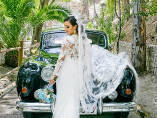 Novia en la Ermita delante del coche nupcial clasico