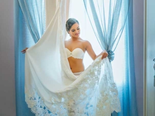 Novia en lencer&iacute;a, mirando su vestido de boda