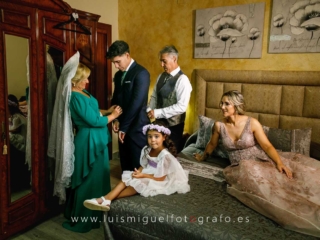 Novio-ayudado-a-vestirse-por-su-familia-antes-de-su-boda