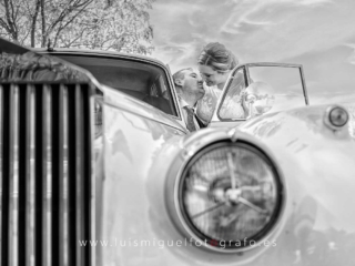 Recien casados besandose en el Rolls Royce nupcial