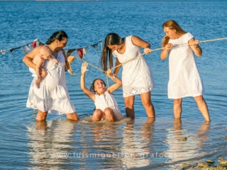 foto-de-nina-de-comunion-informal-con-mama-hermanas-y-abuela-jugando-en-el-agua