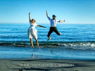 foto de postboda con novios saltando en la orilla de la playa
