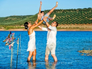 nino-de-comunion-con-sus-papas-jugando-en-el-agua